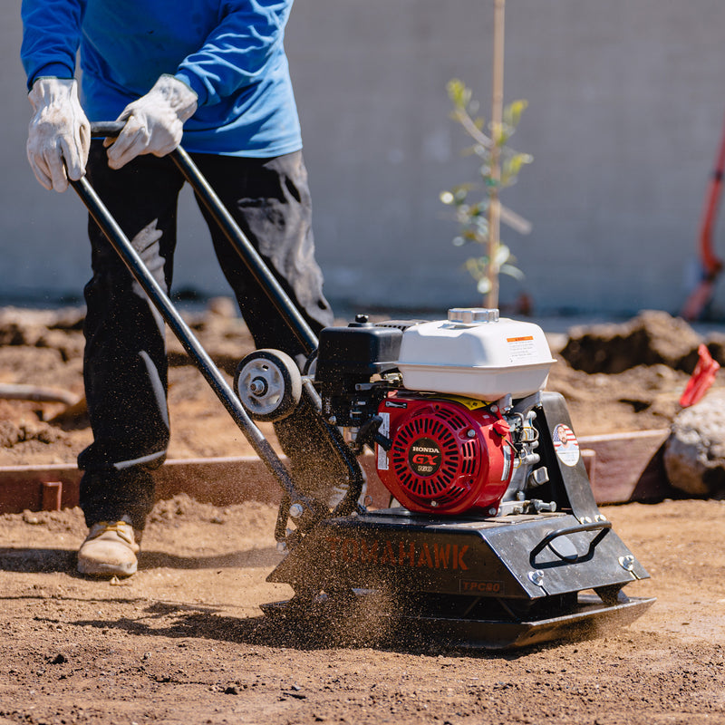 Operator using a Honda GX-powered plate compactor